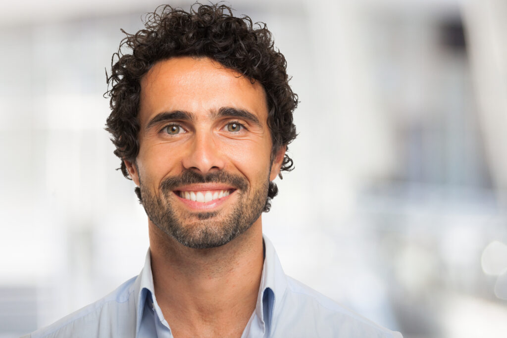 Close-up portrait of a smiling man.